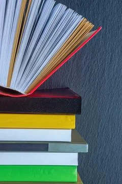Stack of different books against black background. Copy space Stock Photos