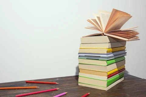 Stack of different books and red pencils on dark rustic table. Copy space Stock Photos