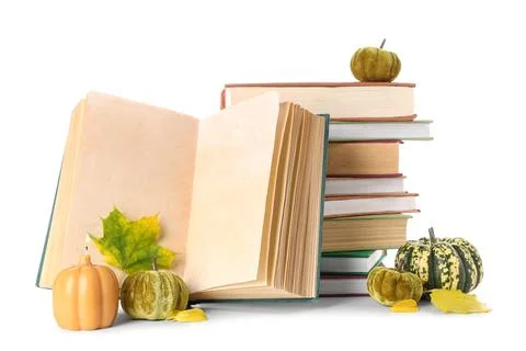 Stack of different books with burning candle, decorative pumpkins and autumn  Stock Photos