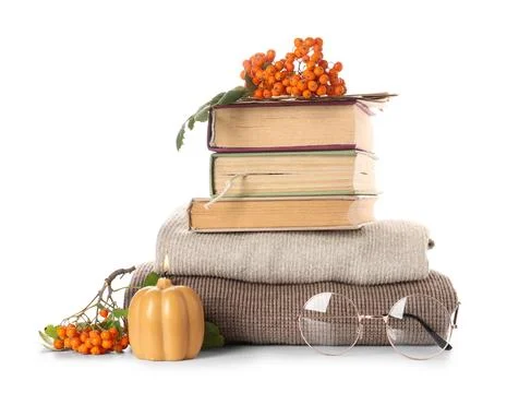 Stack of different books with burning candle, eyeglasses, and rowan berries o Stock Photos