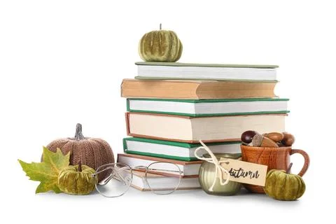 Stack of different books with burning candle, decorative pumpkins, eyeglasses Stock Photos