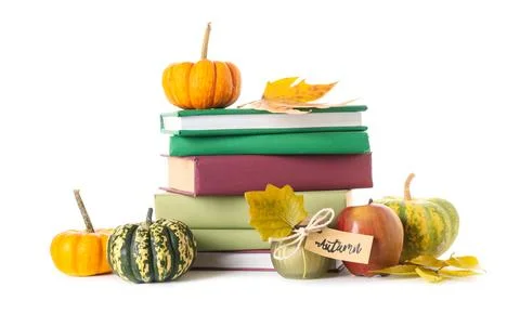 Stack of different books with candle, pumpkins, apple and autumn leaves on wh Stock Photos