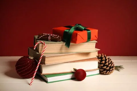 Stack of different books, Christmas balls and gift box on white wooden table, Stock Photos