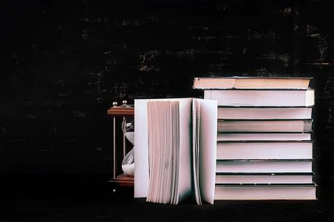 Stack of different books on dark background. Knowledge concept. Photos