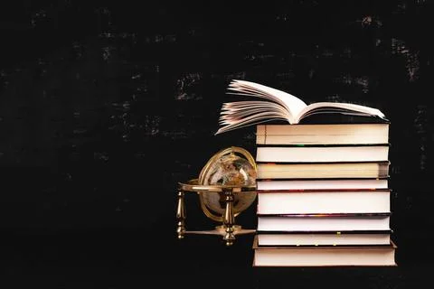 Stack of different books on dark background. Knowledge concept. Photos