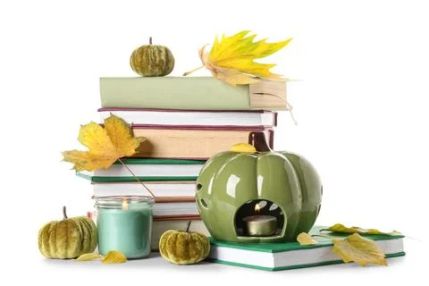 Stack of different books with decorative pumpkins, burning candles and autumn Stock Photos
