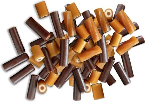 Stack of different caramel sweets isolated on white background. Top view. Stock Photos