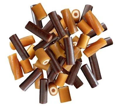 Stack of different caramel sweets isolated on white background. Top view. Stock Photos