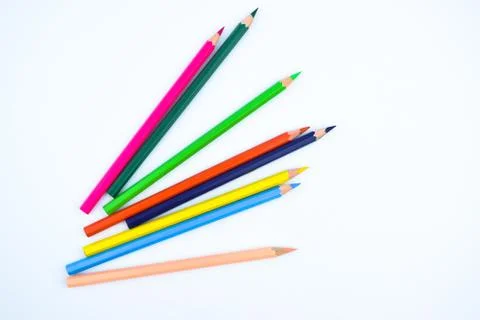 Stack of different colored wood pencil crayons placed on a white paper backgr Stock Photos