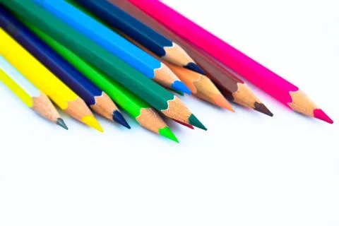 Stack of different colored wood pencil crayons scattered across a white backg Stock Photos