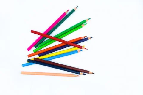 A stack of different colored wood pencil crayons placed on a white paper back Stock Photos