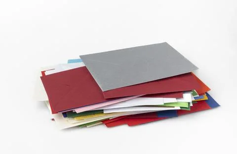 Stack of different coloured envelopes white background 写真素材