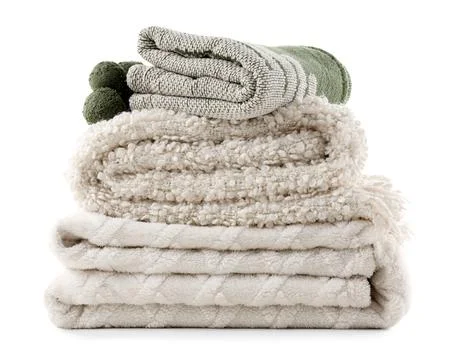 Stack of different cozy blankets isolated on white background Fotos de archivo