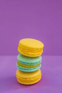 A stack of different flavours of macaroons biscuits on violet purple backgrou Stockfoto's