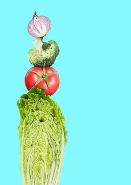 Stack of different fresh vegetables on light blue background, space for text Foto stock
