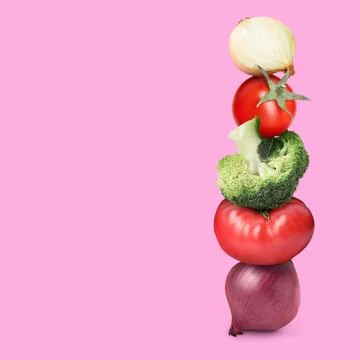 Stack of different fresh vegetables on pink background, space for text Stockfoto's