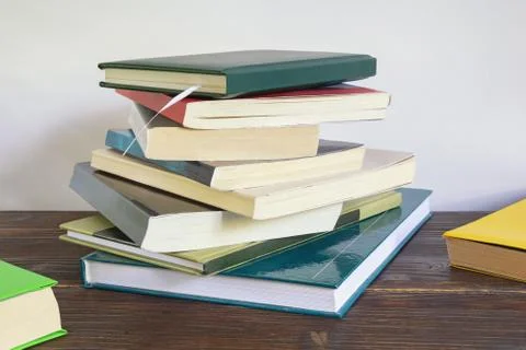 Stack of different multi-colored books on table. Copy space Stock Photos