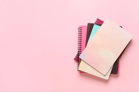Stack of different notebooks on pink background Stock Photos
