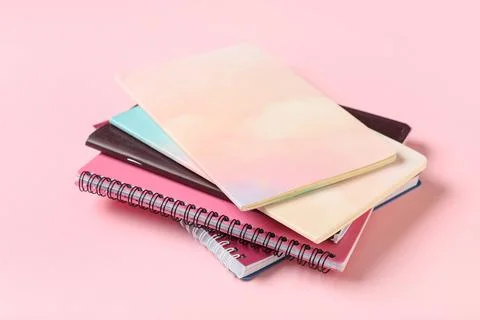 Stack of different notebooks on pink background Stock Photos