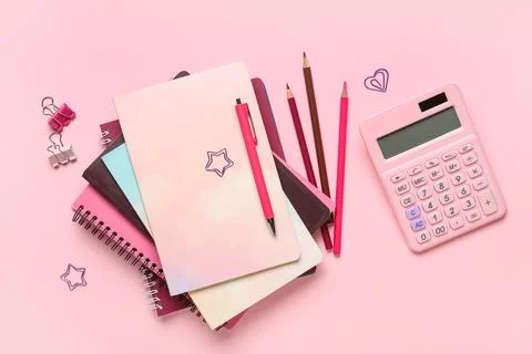 Stack of different notebooks with stationery and calculator on pink backgroun Stock Photos