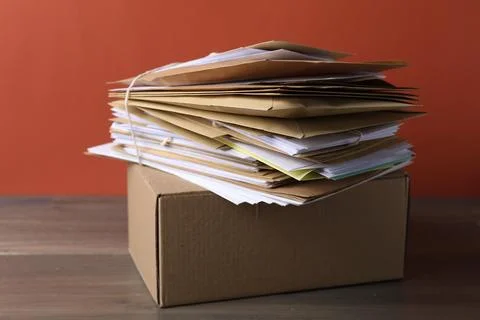 Stack of different paper envelopes and parcel on wooden table, closeup. Pos.. Foto stock