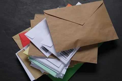 Stack of different paper envelopes on black table, top view. Post office 스톡 사진