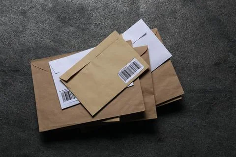 Stack of different paper envelopes on dark grey table, top view. Post office 스톡 사진
