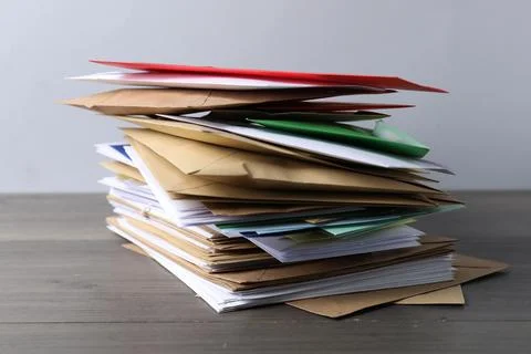 Stack of different paper envelopes on wooden table, closeup. Post office Foto stock