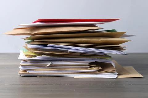 Stack of different paper envelopes on wooden table, closeup. Post office Foto stock