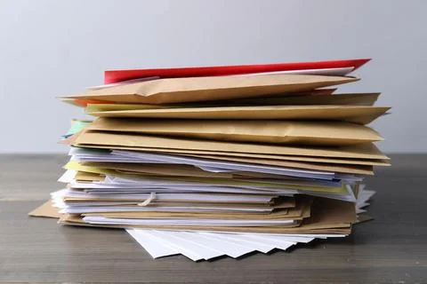 Stack of different paper envelopes on wooden table, closeup. Post office Foto stock