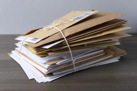Stack of different paper envelopes on wooden table, closeup. Post office Foto stock