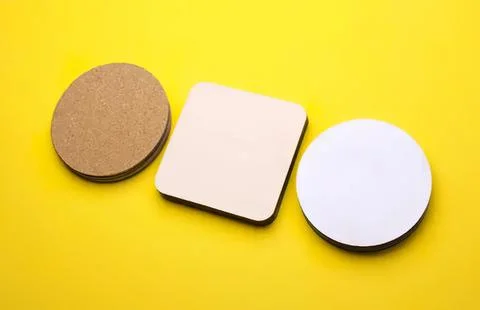 Stack of different shaped coasters on yellow background Stock Photos