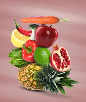 Stack of different vegetables and fruits on pale dusty pink background 스톡 사진