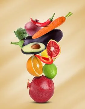 Stack of different vegetables and fruits on pale gold background 스톡 사진