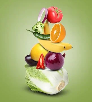 Stack of different vegetables and fruits on pale yellow green background Stockfoto's