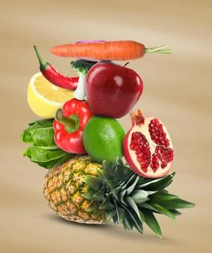 Stack of different vegetables and fruits on pale light brown background 스톡 사진