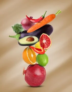 Stack of different vegetables and fruits on pale light brown background 스톡 사진