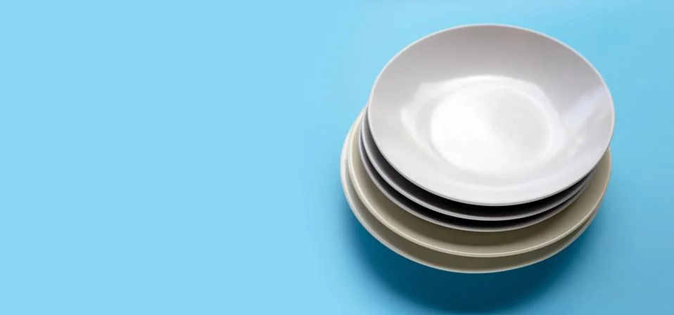 Stack of dishes on blue background. Stock Photos