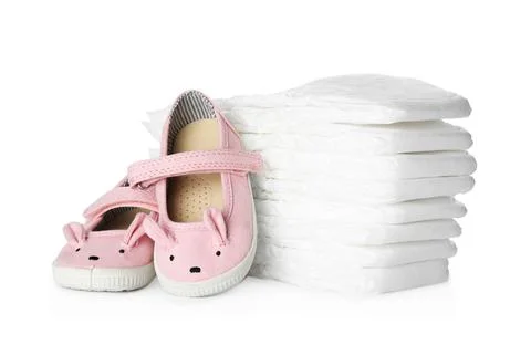 Stack of disposable diapers and child's shoes on white background 스톡 사진