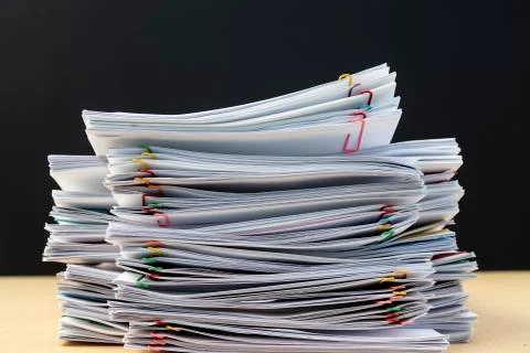 Stack of document paper with colorful paperclip place on wooden table. Stock Photos