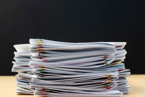 Stack of document paper with colorful paperclip place on wooden table. Stock Photos