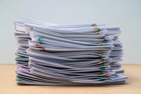 Stack of document paper with colorful paperclip place on wooden table. Stock Photos
