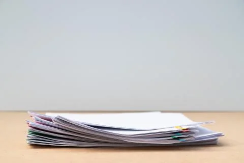 Stack of document paper with colorful paperclip place on wooden table with co Stock Photos