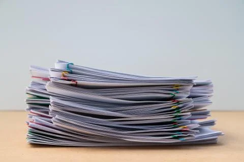 Stack of document paper with colorful paperclip place on wooden table. Stock Photos