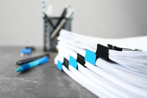 Stack of documents with binder clips on grey stone table, closeup view. Space 写真素材