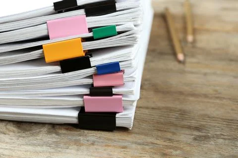 Stack of documents with colorful binder clips on wooden table, closeup 스톡 사진