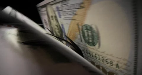 Stack of dollar banknotes put into bill counter for calculation Stock Footage 242095815