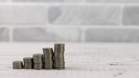 Stack of dollar banknotes rolled up with rubber near money coin towers Stock Footage 126430950