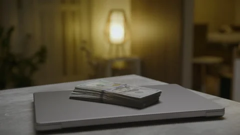 Stack of dollar bills on closed laptop Stock Footage 330888182