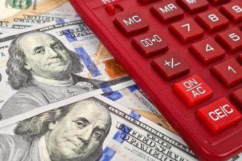 Stack of dollar bills with a red calculator Foto stock